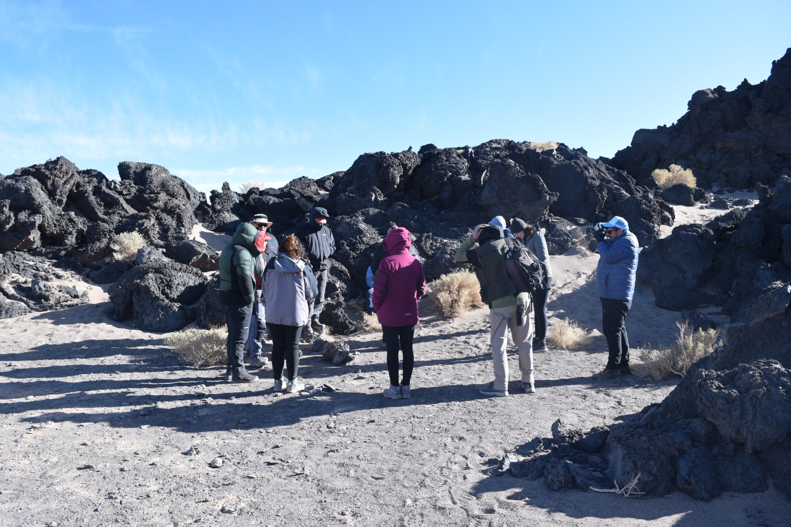 Turistas aprendiendo sobre formación de volcanes y geociencias en la Puna catamarqueña.